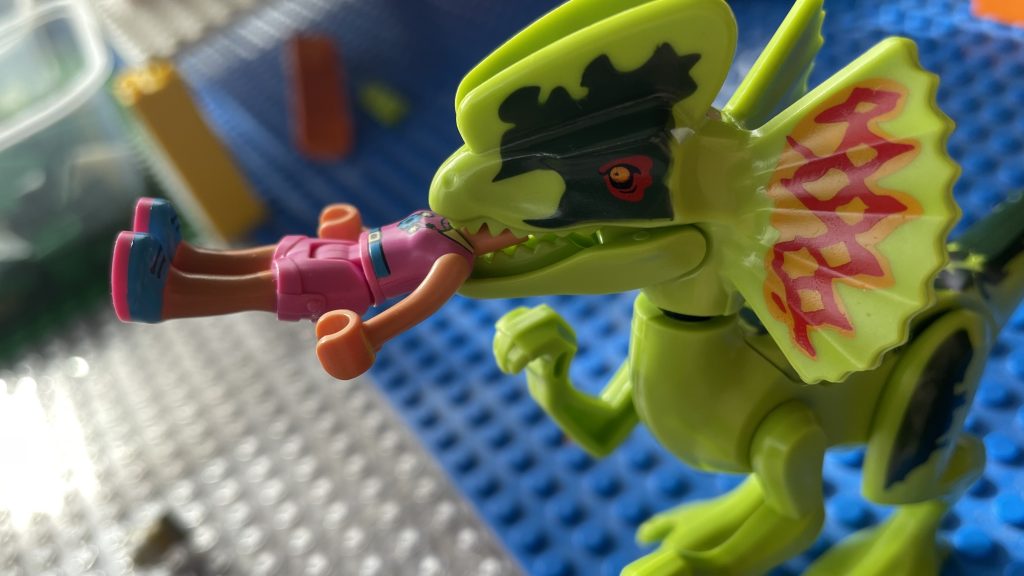 Dilophosaurus minifigure with another minifigure in its jaws.