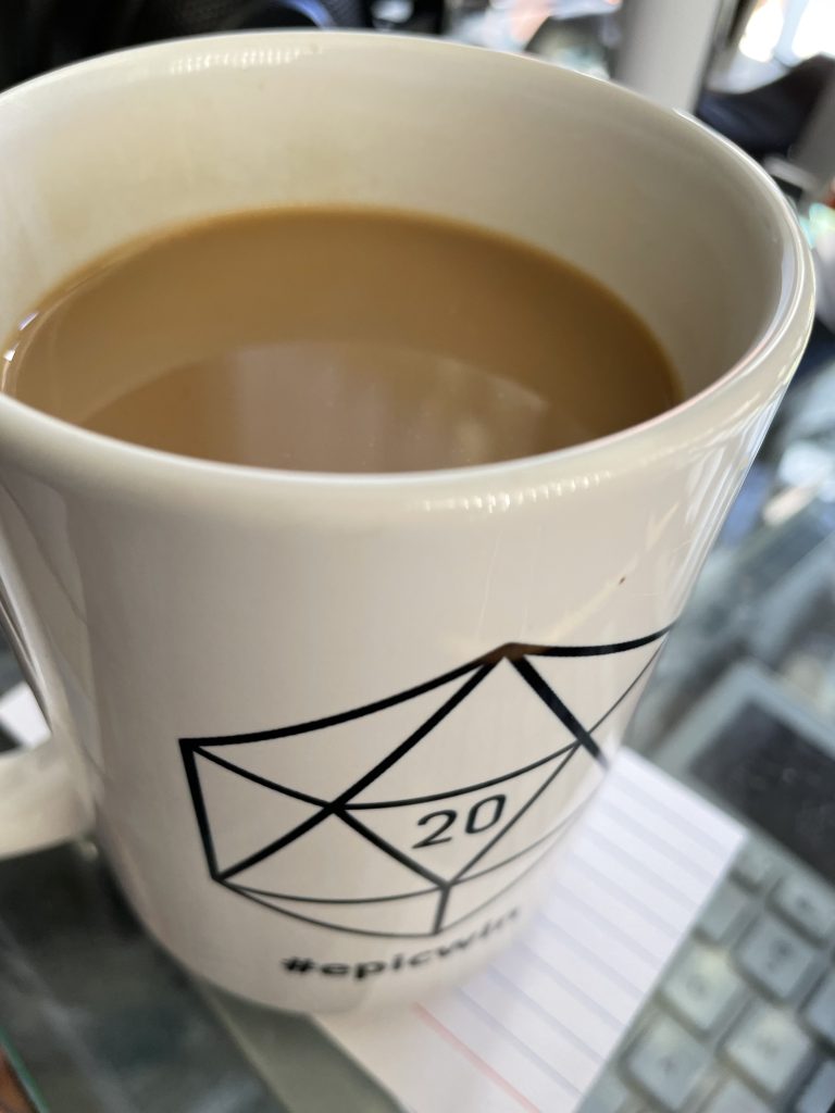 A coffee mug with a 20-sided die design, showing a 20. On the bottom it says #epicwin.